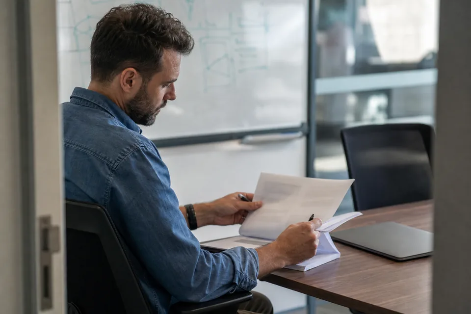 Engineering director reviewing a vendor renewal contract at a conference table